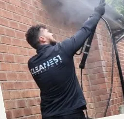Exterior cleaner pressure washing a gutter