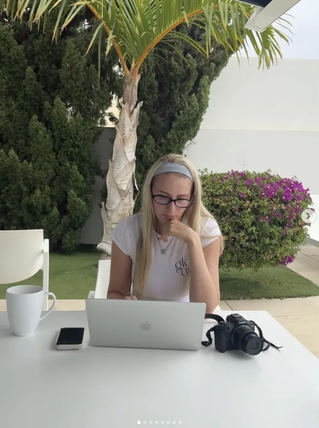 Keely planning content on a laptop outdoors with her camera beside her